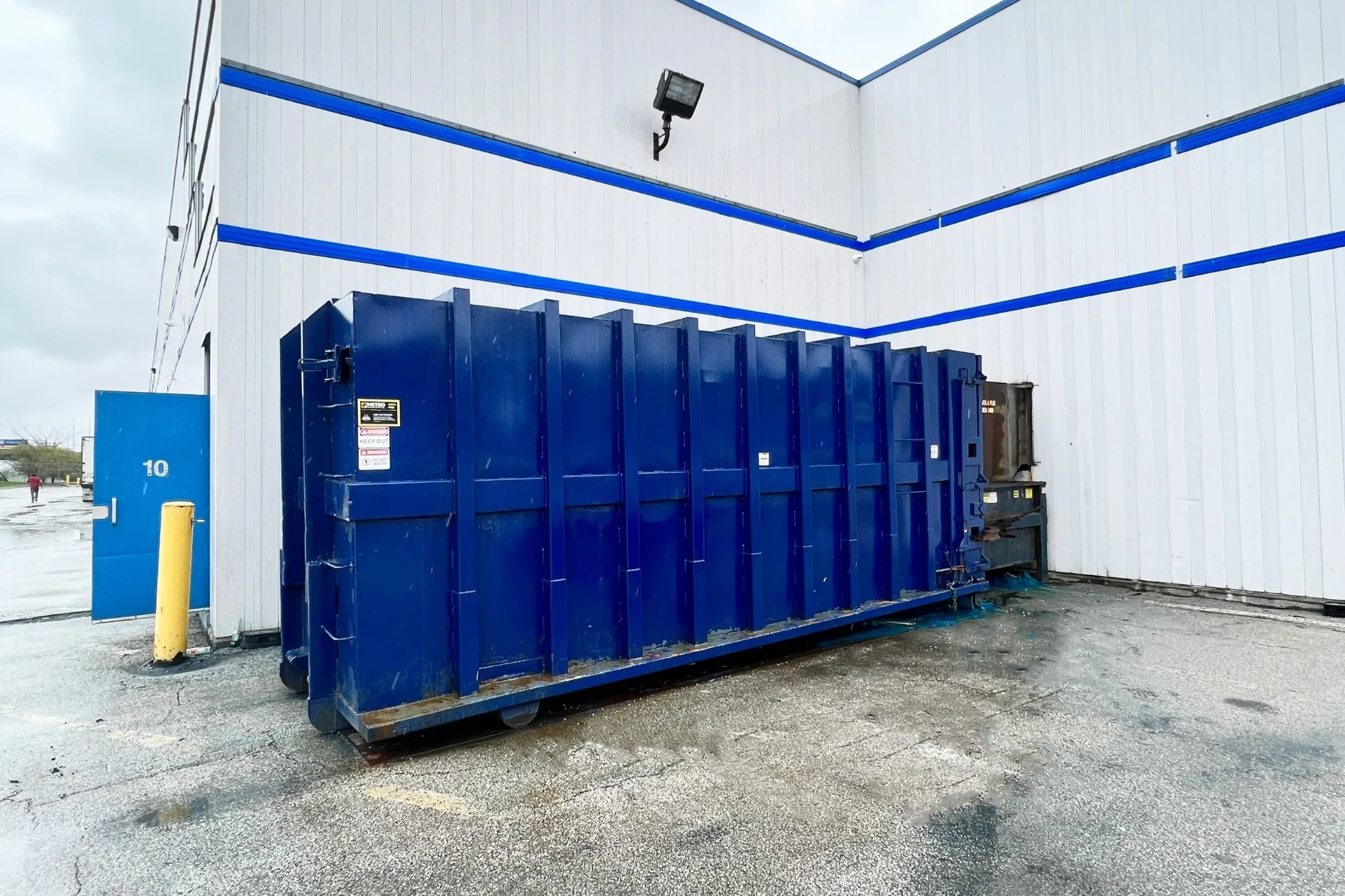 Industrial compactor for wood waste recycling outside a commercial facility